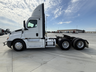Freightliner PT126064S Daycab tractor side view showing sleeper cab, fuel tanks, and dual rear axles with wheels; VIN label not visible.
