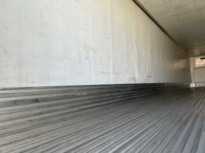 Trailer interior showing ribbed aluminum floor and smooth side walls with light from open end