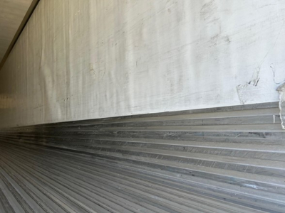 Trailer interior edge showing metal ribbed floor with side wall; no additional labels visible.