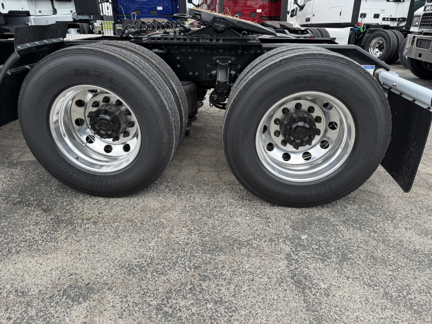 Rear dual axles with dual tires showing wheels and suspension components of a Volvo VNL truck.