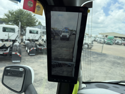 Volvo VNL64T860 sleeper tractor cab interior displaying a vertical tablet-style monitor mounted near windshield with rearview and fleet yard scene outside.