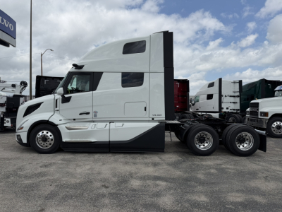 Side view of a white 2027 Volvo VNL64T860 tractor cab chassis showing sleeper cab, chrome wheels, and dual rear axles.
