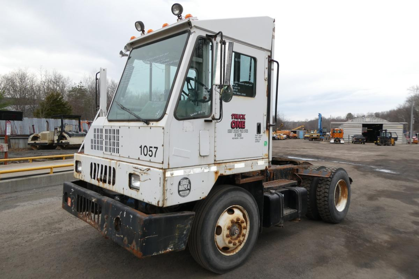 Truck cab and chassis showing Ottawa 2006 yard truck with white cab, large windshield, front grille, and rust on lower bumper; number 1057 on grille and stock 0325261 text on door.