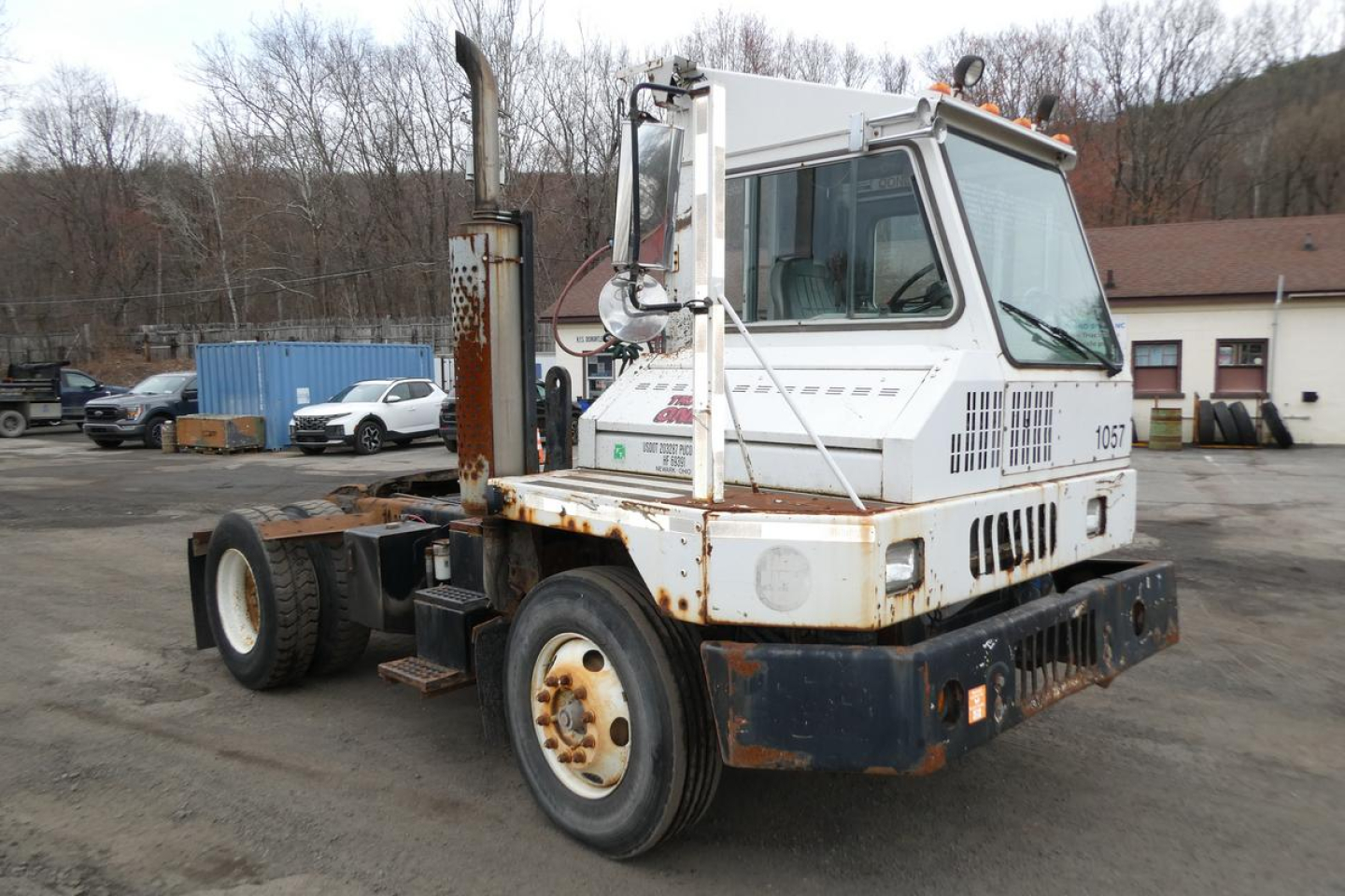 Industrial yard truck showing a white Ottawa 30 terminal tractor with rusted chassis and black bumper, side exhaust, and large rear tires.