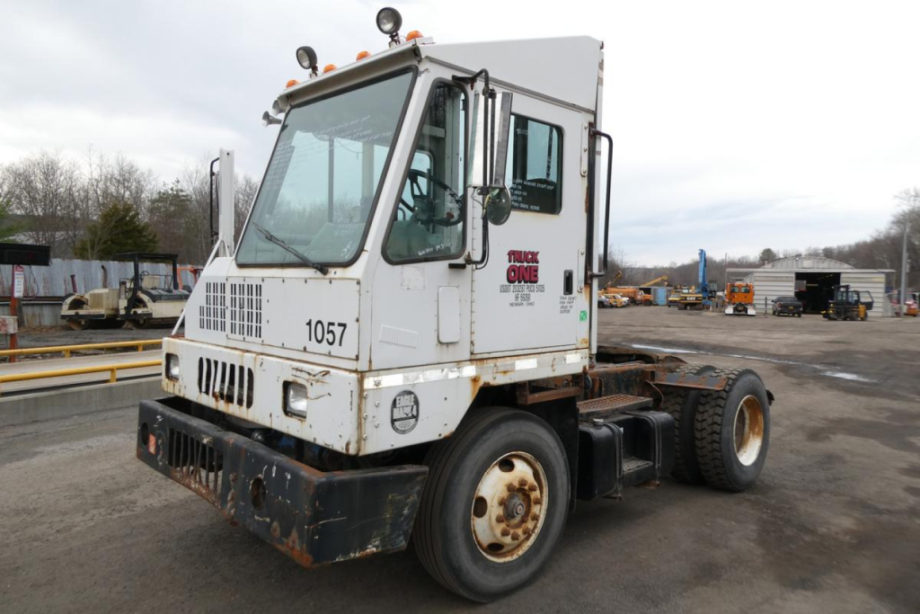 Truck cab and chassis showing Ottawa 2006 yard truck with white cab, large windshield, front grille, and rust on lower bumper; number 1057 on grille and stock 0325261 text on door.