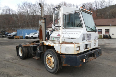 Industrial yard truck showing a white Ottawa 30 terminal tractor with rusted chassis and black bumper, side exhaust, and large rear tires.