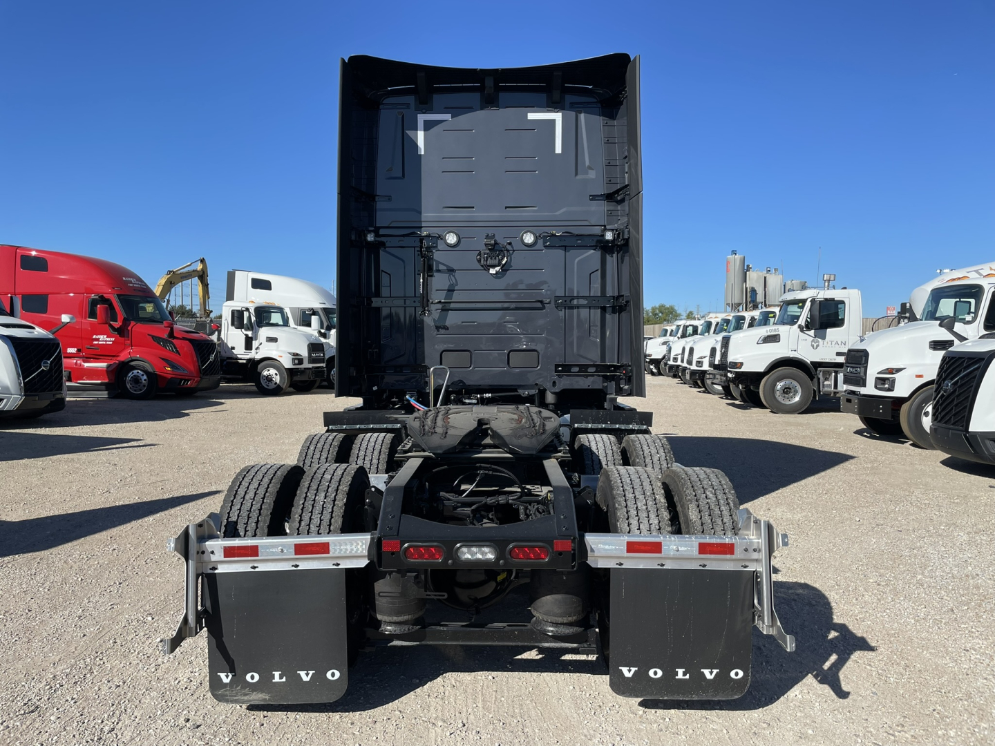 Truck rear view showing fifth wheel and dual rear axles of a new Volvo VNL64T860 in a truck lot.