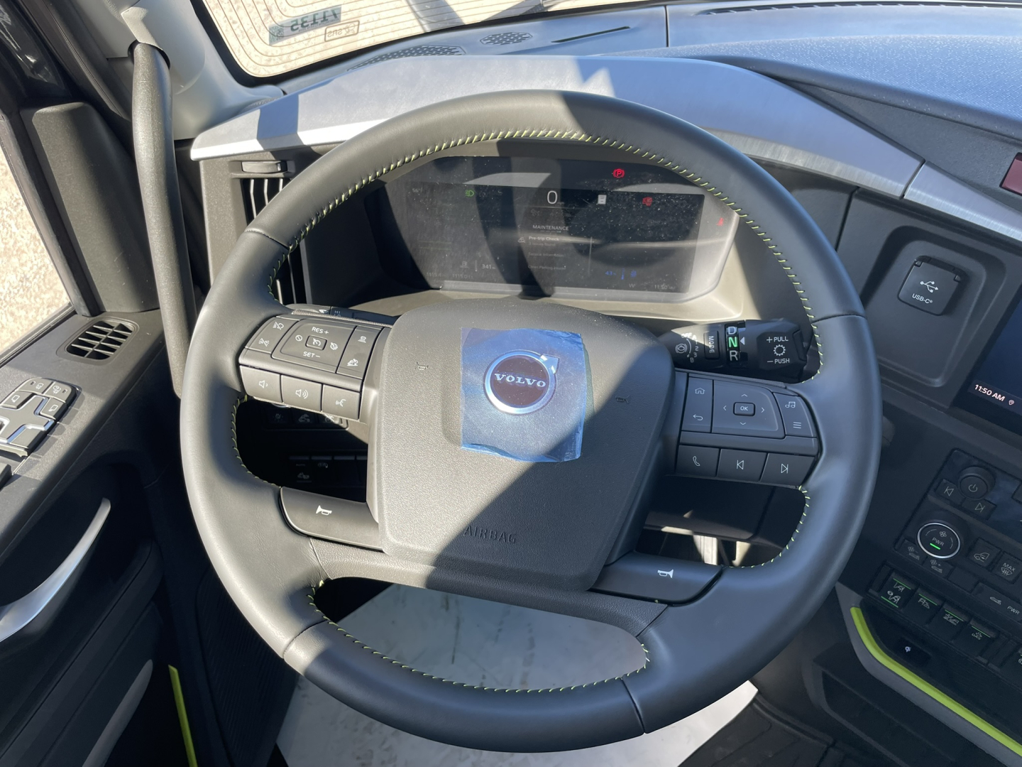 Volvo VNL64T860 truck interior showing steering wheel with Volvo logo and digital gauge cluster.