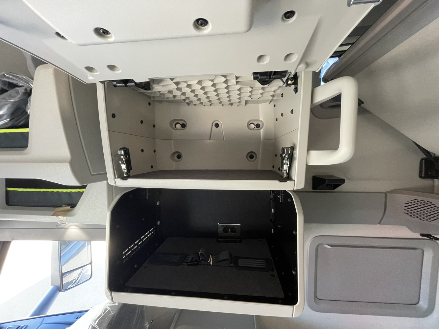 Volvo VNL64T860 cabin area showing empty storage compartments and overhead dash, with open storage boxes in view