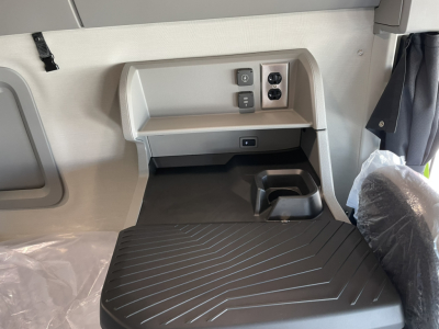 Cabin area of a 2026 Volvo VNL sleeper showing side console with power outlets and storage compartment.