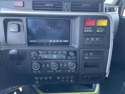 Dashboard of a Volvo VNL64T860 cab showing center touchscreen, climate controls, and warning/light switches.