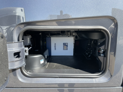 Front storage area of a new Volvo VNL64T860 sleeper cab showing an Xantrex inverter/charger unit and surrounding compartments.
