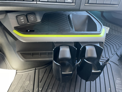 Volvo VNL64T860 interior showing cup holders and bright green trim along center console near floor mats.