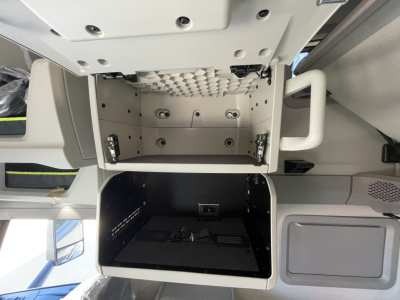 Volvo VNL64T860 cabin area showing empty storage compartments and overhead dash, with open storage boxes in view