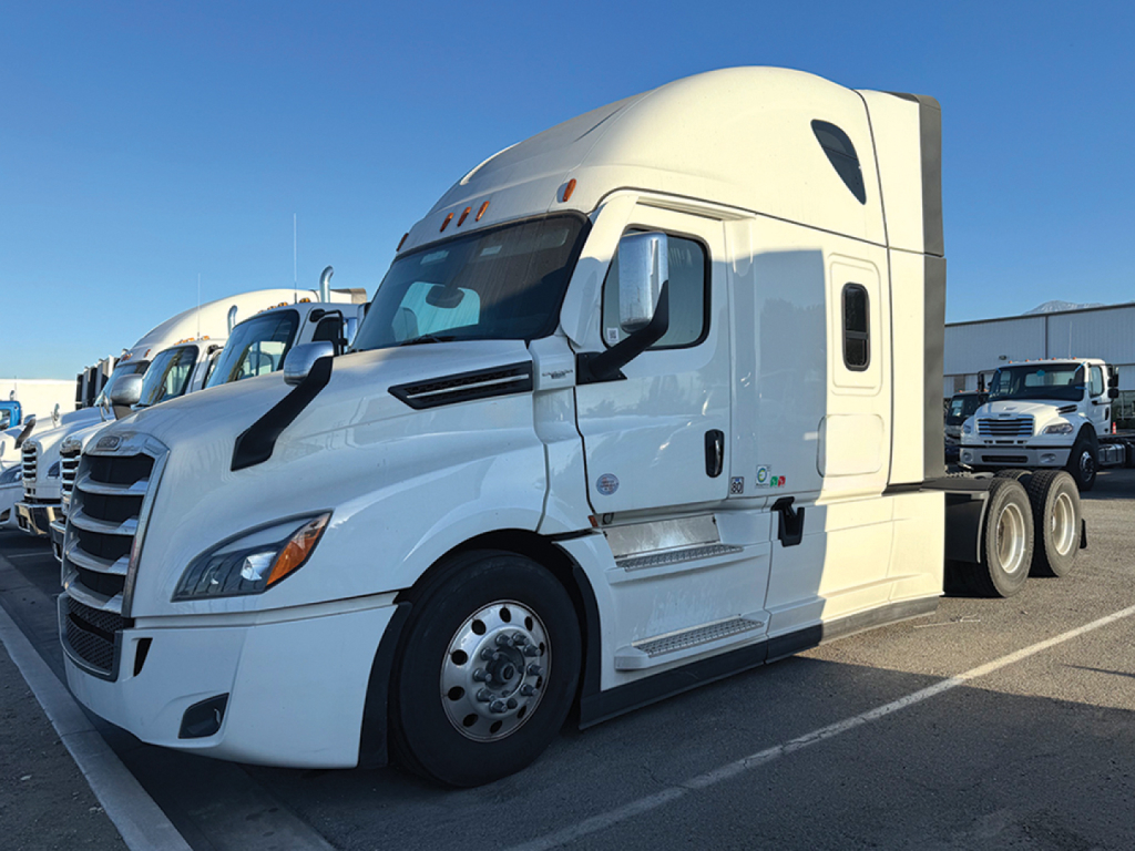Freightliner Cascadia126 truck in a lot, front and side view showing sleeper cab and wheels.