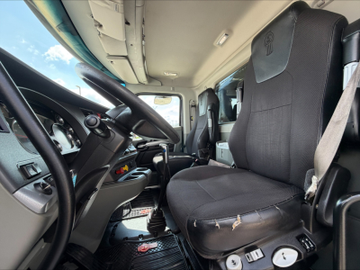 Kenworth T880 truck cabin interior showing driver seat and steering wheel with dashboard controls.