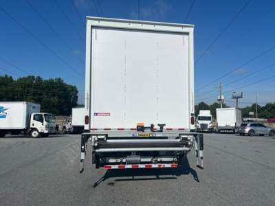 Rear view of a Freightliner M2 106 Plus box truck with liftgate, white exterior, and visible bumper safety lights.