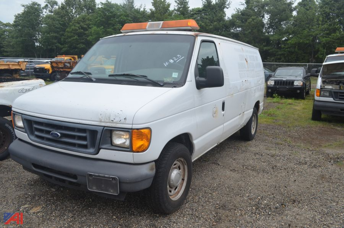 Ford Econoline cargo van in-service showing front grille and orange rooftop warning lights.