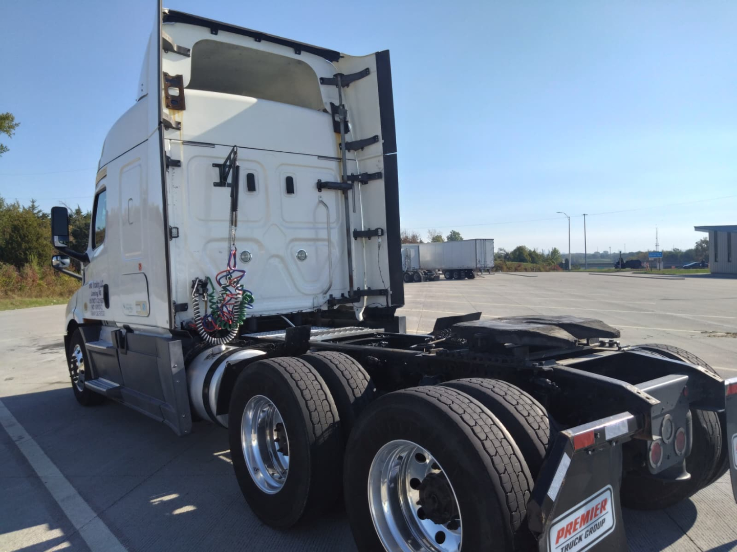Truck chassis and rear view showing dual rear axles and sleeper cab of a 2020 Freightliner Cascadia with fifth wheel area and rear light modules visible.