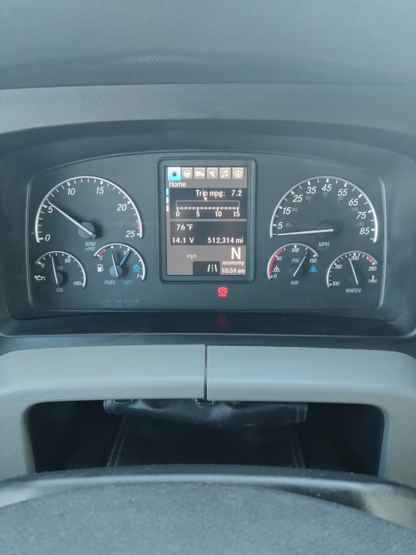 Dashboard view of a 2020 Freightliner Cascadia showing instrument cluster and digital display with trip mpg, battery, and engine indicators.
