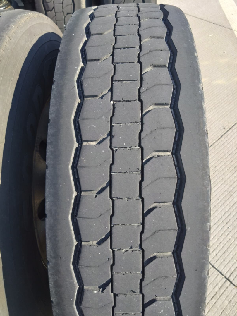 Tire tread close-up on Freightliner Cascadia truck showing heavy wear and center rib pattern.