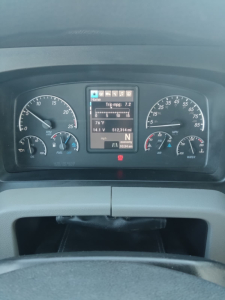 Dashboard view of a 2020 Freightliner Cascadia showing instrument cluster and digital display with trip mpg, battery, and engine indicators.