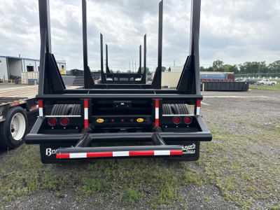 Trailer rear view showing classically stacked vertical stakes on Viking log trailer with reflective strips and rear bumper.