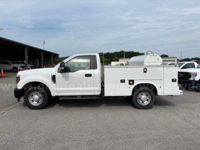 Ford F-250 utility/service bed truck in side view with storage box and equipment cabinet, white exterior, regular cab, standard wheels.