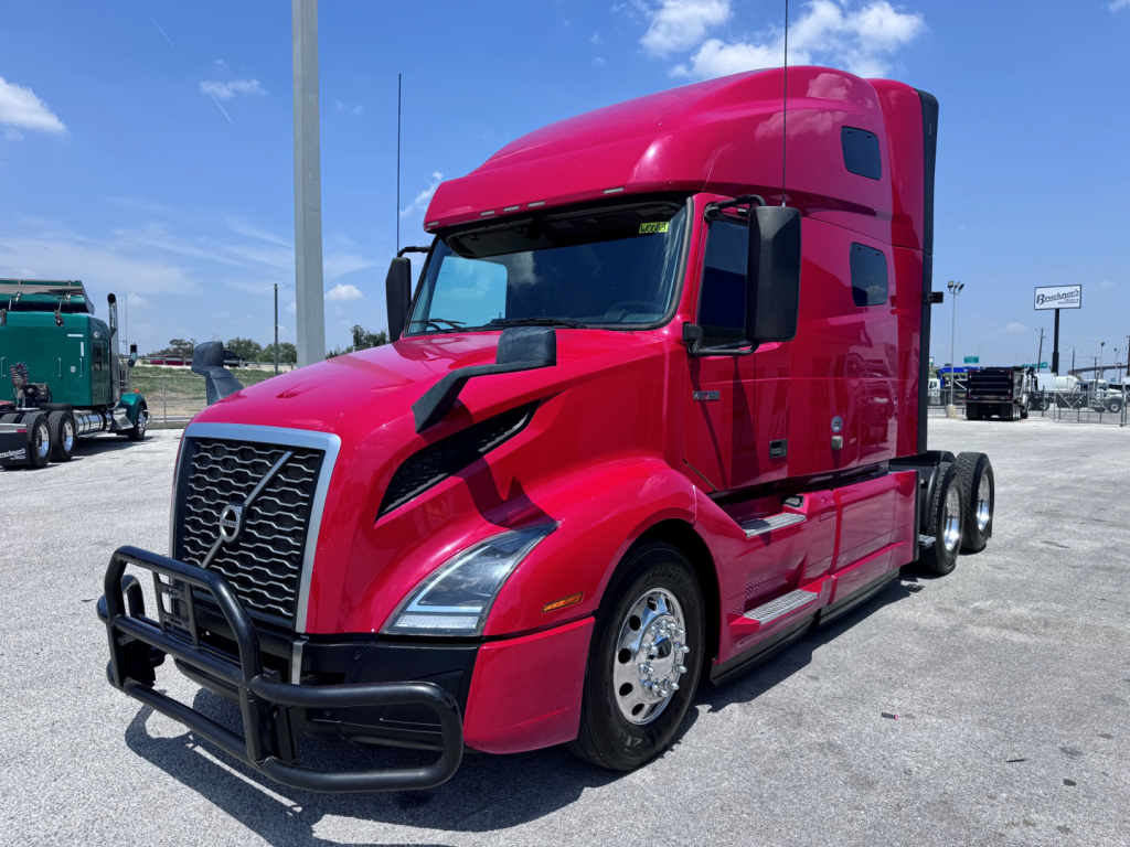 Volvo VNL64T760 sleeper tractor in red with black grille guard. Visible text on bumper and hooding includes Volvo logo on grille. No legible small print readable on side panels.