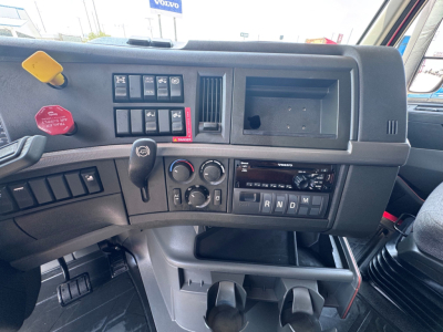 Volvo VNL64T760 truck cabin dashboard with steering column and control panels; visible texts include ABS/air switch cluster, 12V outlet, climate controls, radio, R N D M indicator, and Volvo branding.