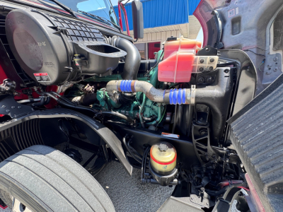Volvo VNL64T760 engine bay showing coolant reservoir and various hoses, wiring, and components.