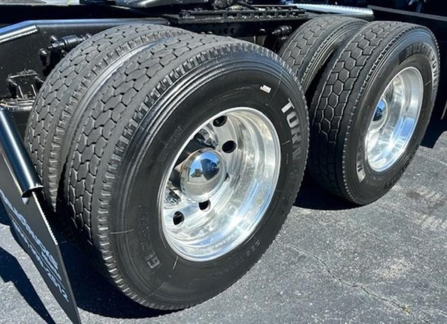 Freightliner Cascadia 126 dual rear wheels showing polished chrome rims and tire tread, part of a truck chassis.
