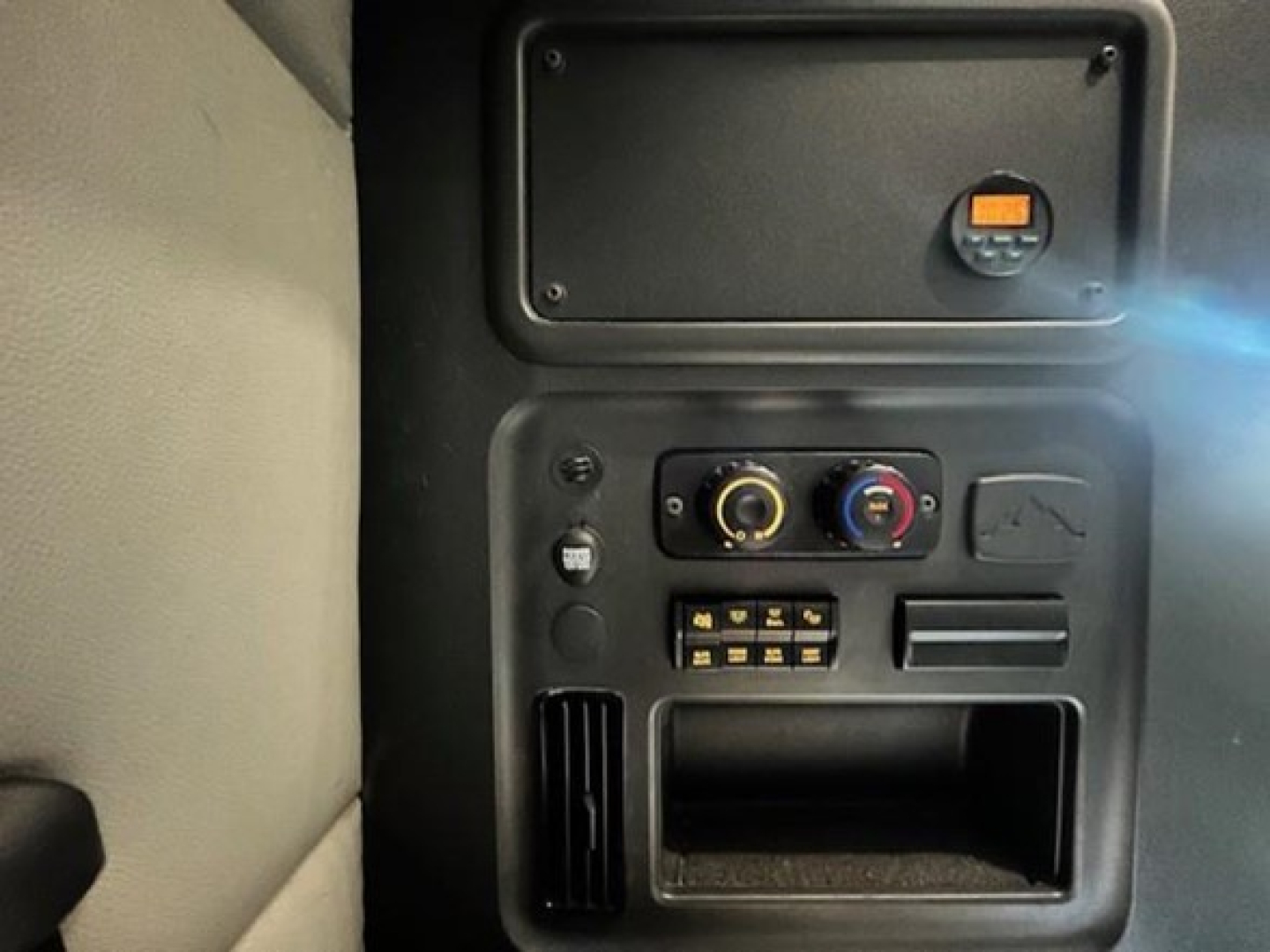 Cab interior dash area showing control panel and storage compartment in a Freightliner Cascadia truck cab.