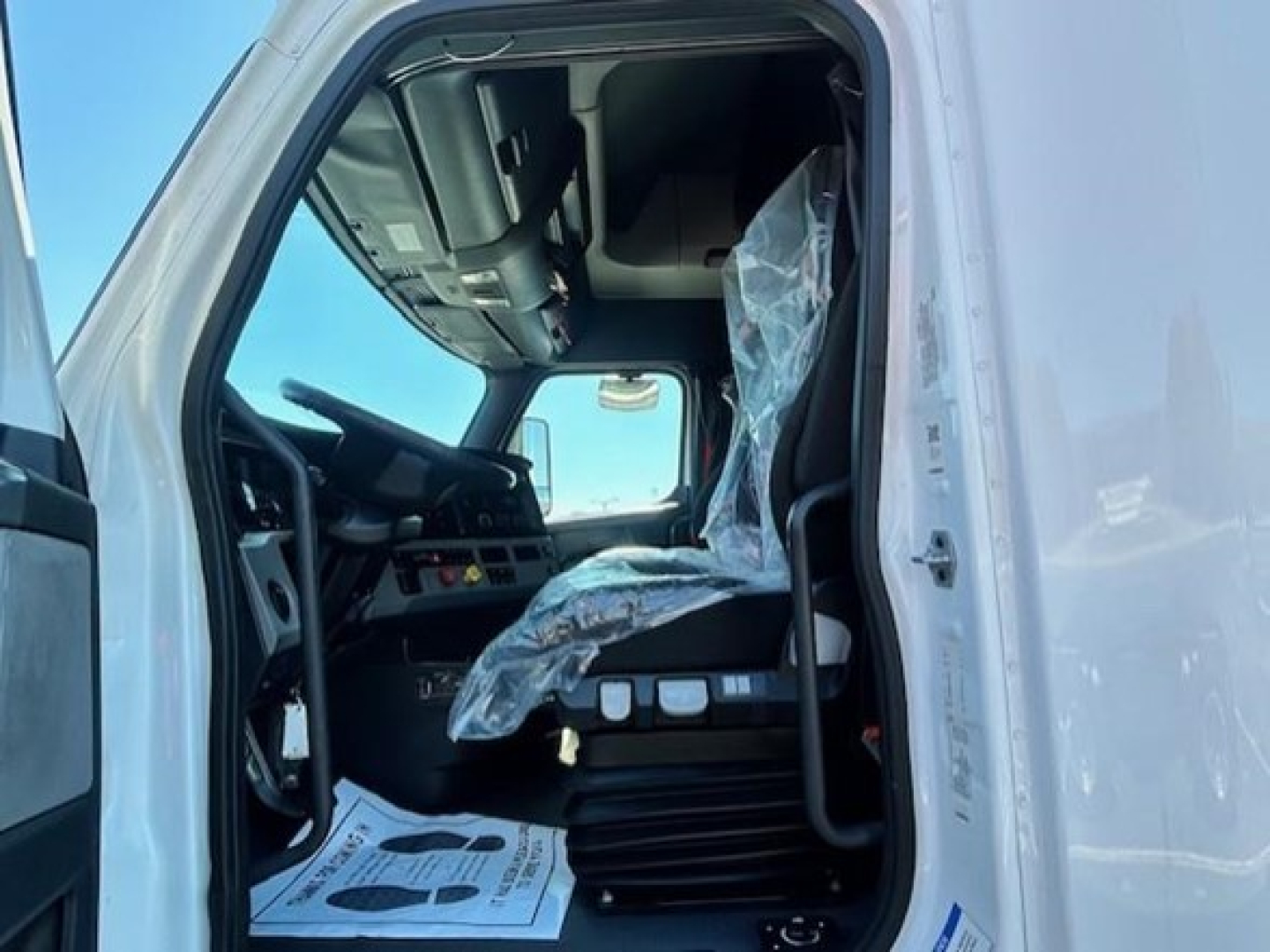 Cabin interior of a Freightliner Cascadia truck showing driver's seat and dashboard area.