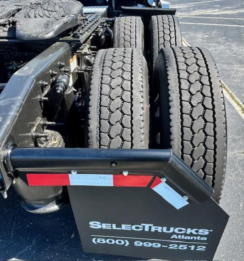 Truck chassis with dual rear axles and SelectTrucks Atlanta sign on mudguard showing (800) 999-2512.
