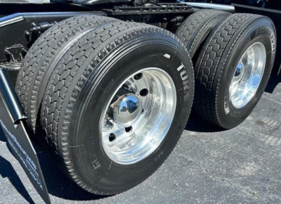Freightliner Cascadia 126 dual rear wheels showing polished chrome rims and tire tread, part of a truck chassis.