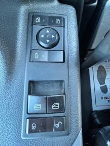 Freightliner Cascadia 126 interior switch panel showing window control buttons and circular navigation pad.