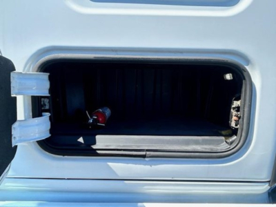 Truck cab storage hatch open showing interior storage area with hinge and latch