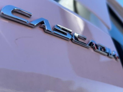 Freightliner Cascadia emblem on the truck rear showing chrome lettering 'CASCADIA' with lavender/purple paint.