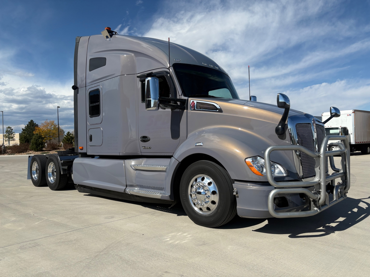 Kenworth T680 2022 conventional sleeper truck in silver profile view showing cab with aero mirrors and chrome bumper.