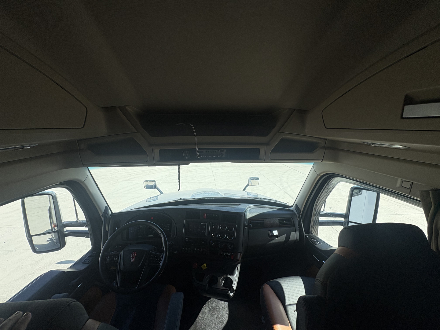 Kenworth T680 cab interior dashboard with steering wheel, gauges, and center console visible.