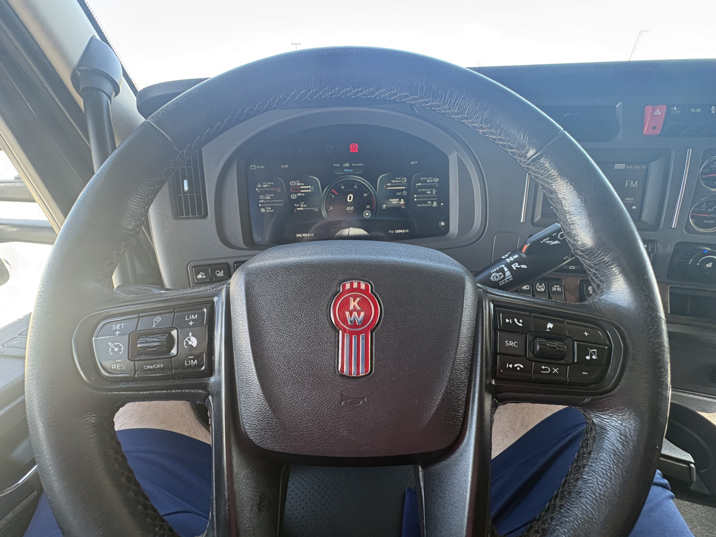 Kenworth T680 cabin steering wheel with KW emblem and dashboard controls visible