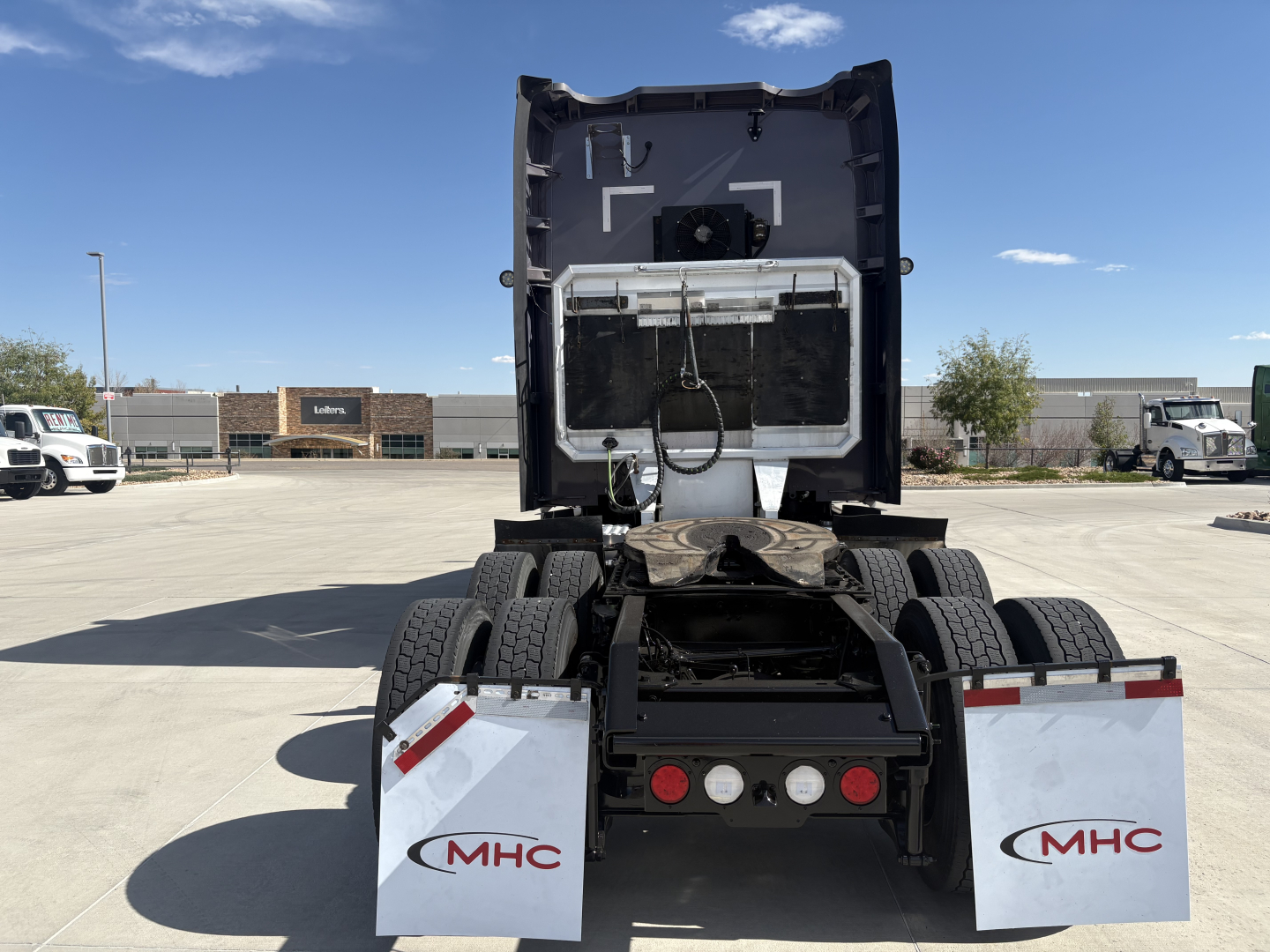 Kenworth T680 tractor rear view showing fifth wheel and dual rear axles with MHC mud flaps.