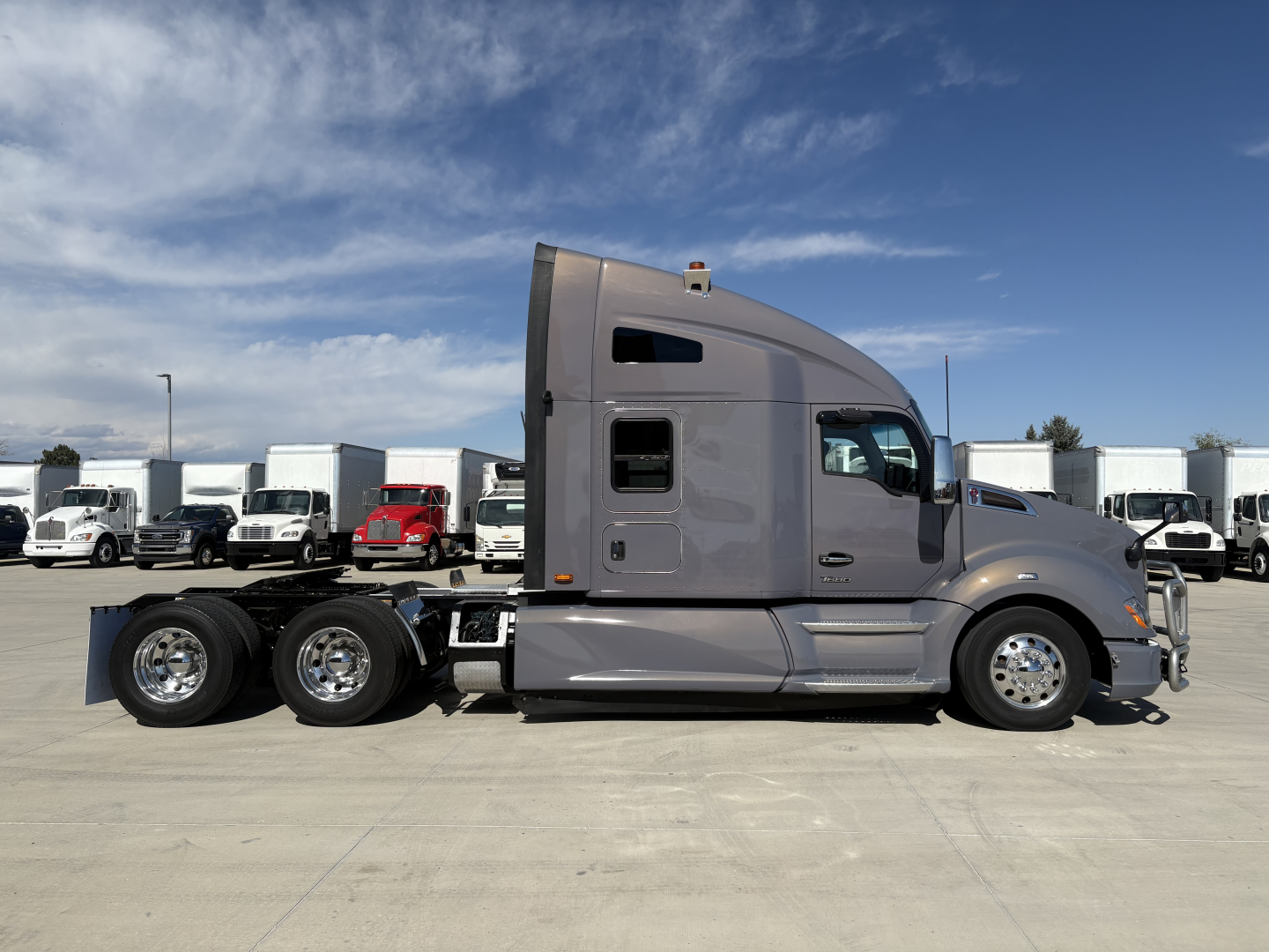 Kenworth T680 tractor-trailer side view showing gray cab and triple rear axles, with stock number 0632478 and VIN 1XKYDP9X8NJ104080 label visible.