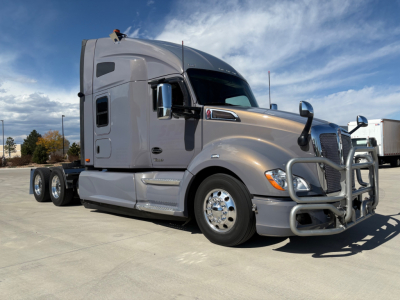 Kenworth T680 2022 conventional sleeper truck in silver profile view showing cab with aero mirrors and chrome bumper.