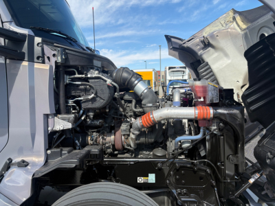 Kenworth T680 engine bay with exposed turbocharger and intercooler piping, visible hoses and components under open hood.