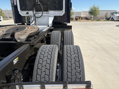 Kenworth T680 chassis showing rear wheel twin tires and fifth wheel area with cab in background.