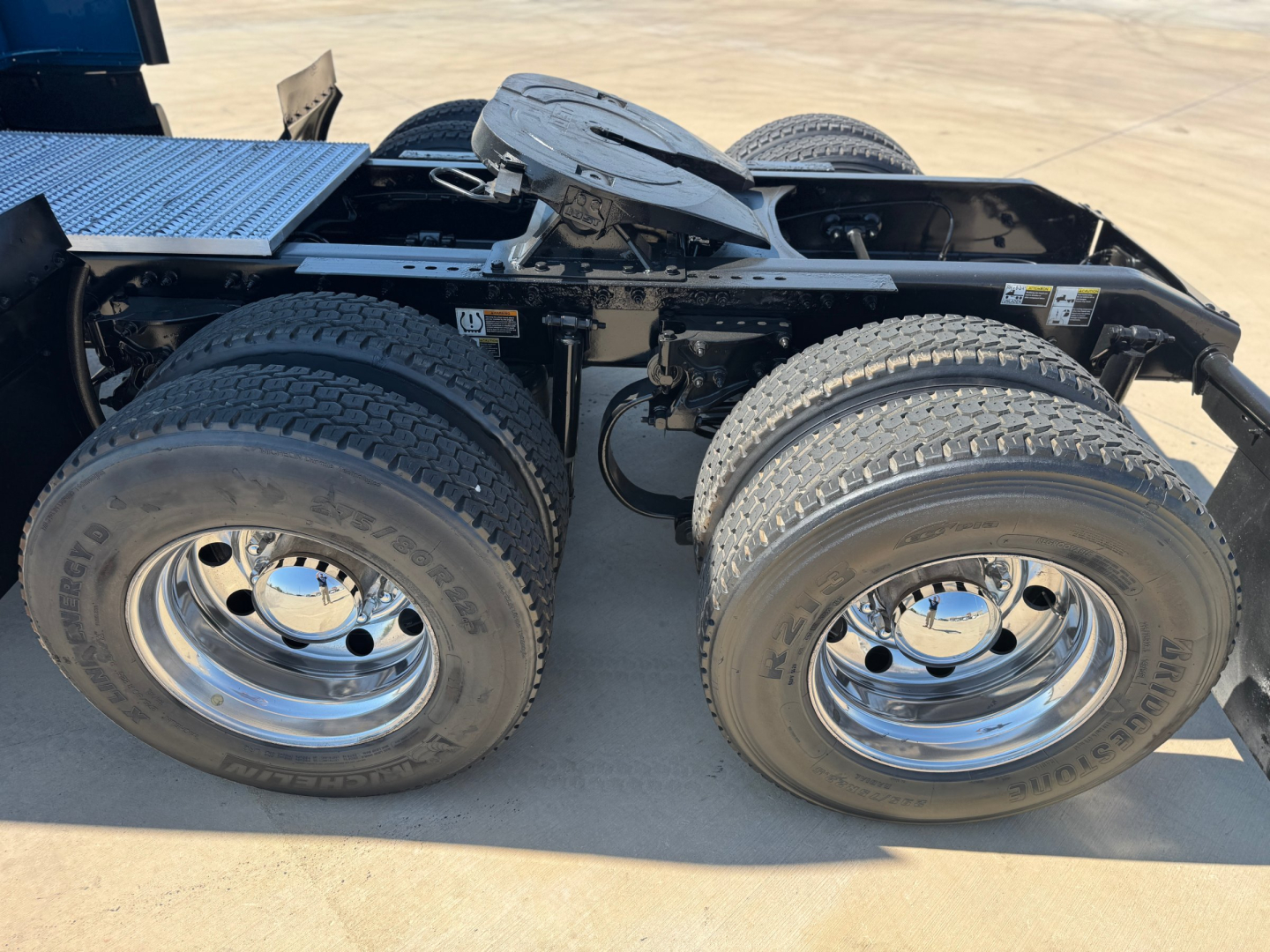 Peterbilt 579 chassis with dual rear axles and chrome wheels, view of the fifth wheel and drivetrain area.
