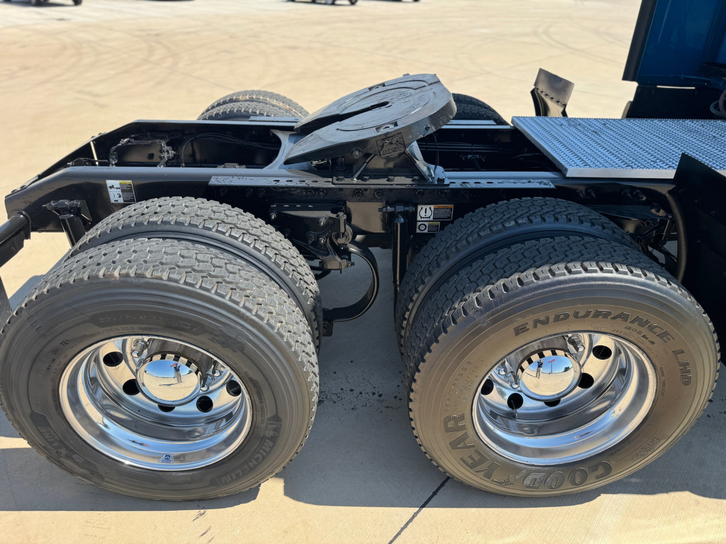 Peterbilt 579 tractor chassis showing dual rear axles with Goodyear Endurance tires and chrome wheels under a sleeper cab, fuel tanks and frame visible.