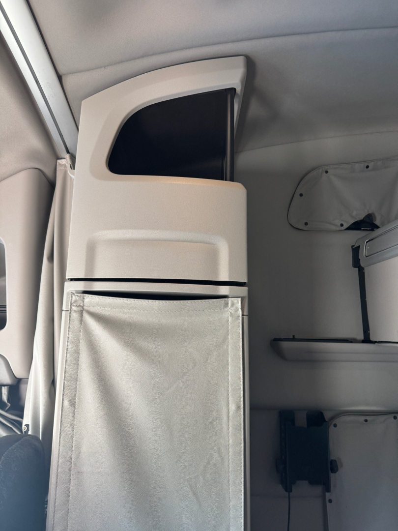 Peterbilt 579 interior vertical storage area and sleeper cabinet with copy of cab wall and overhead panel visible.